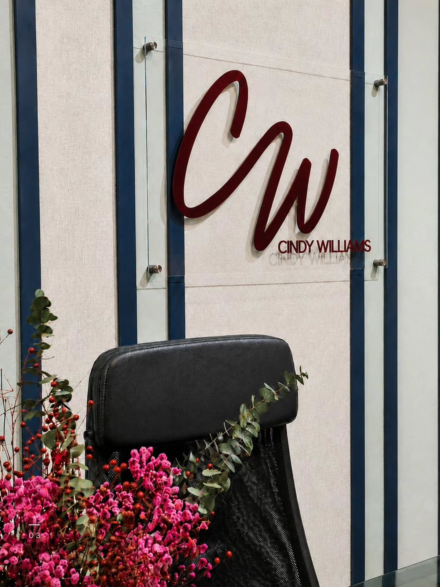 Detalle del letrero 'CW' junto a flores en la recepción de Oficina CW